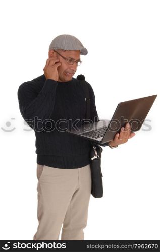 A middle ages Hispanic man standing isolated for white backgroundworking on his laptop and wondering what hi is doing.