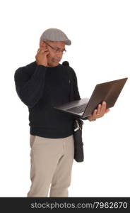 A middle ages Hispanic man standing isolated for white backgroundworking on his laptop and wondering what hi is doing.