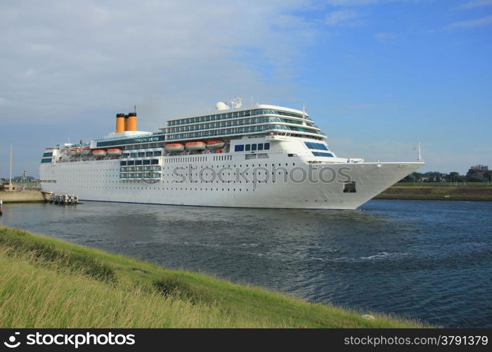 A middle sized cruise ship leaving a dock