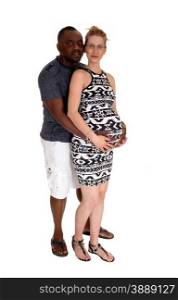 A mixed couple, black man Caucasian woman pregnant standing forwhite background, holding the baby belly.