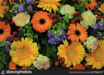 A mixed flower arrangement with yellow and orange gerbers