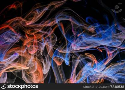 A mixture of colorful ink swirls in water on a black background. Abstract concept photo.