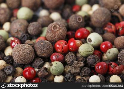 A mixture of different kinds of peppercorns, including black, white, green, grey, pink and Jamaican pepper - or allspice.