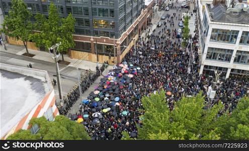 A mob assembles with umbrellas to face off with police in Capital Hill Seattle