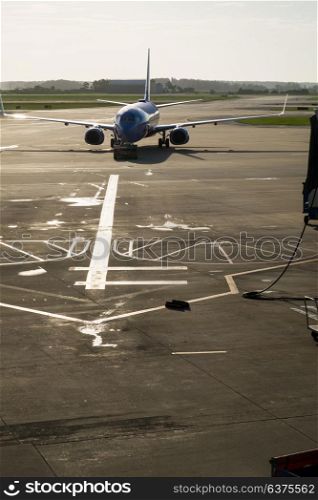 A modern commercial airplane or airliner on the runway at an airport taxiing to the passsenger gate