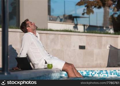 A modern senior man in casual clothes enjoys a vacation in an expensive house. Selective focus. High-quality photo. A modern senior man in casual clothes enjoys a vacation in an expensive house. Selective focus 