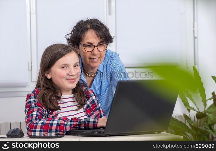 a mom and daughter using a laptop at home