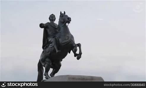 A monument to Peter the great - the bronze horseman and passing airplane.