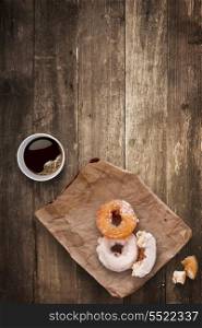 A morning lunch in the office consisted of a cup of black takeaway coffee and tasty donuts.
