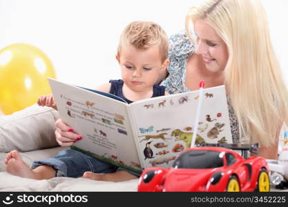 a mother and her baby looking a book