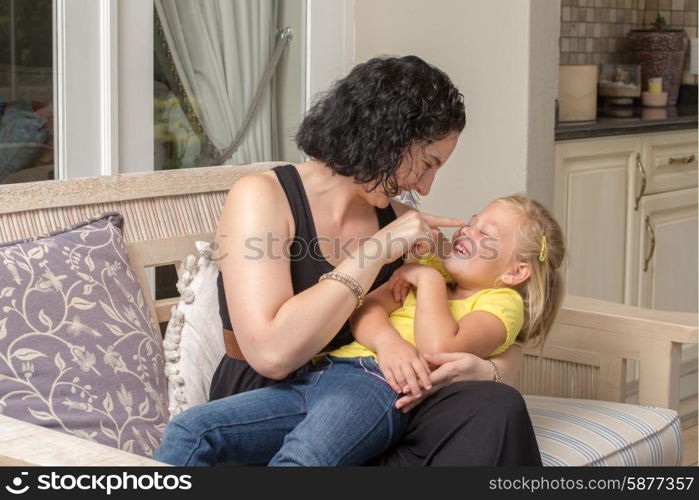 A mother and her young daughter having fun and playing on the patio.