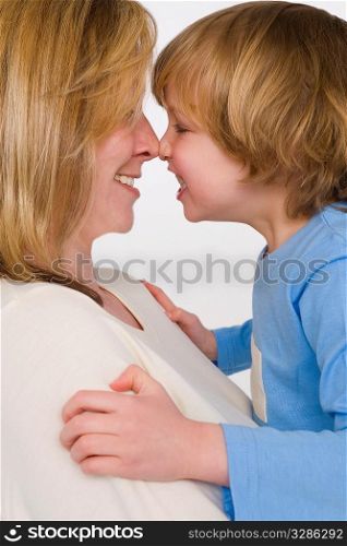 A mother and son nose to nose and laughing