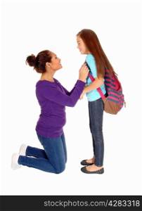 A mother kneeling before her daughter making her ready for school,isolated for white background.