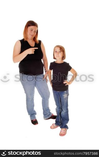 A mother standing behind her little daughter pointing her finger at herisolated for white background.