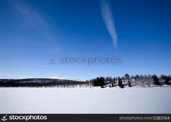 A mountain in the distance over a frozen lake.in winter.
