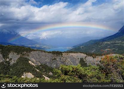 a mountain landscape with a beautiful rainbow