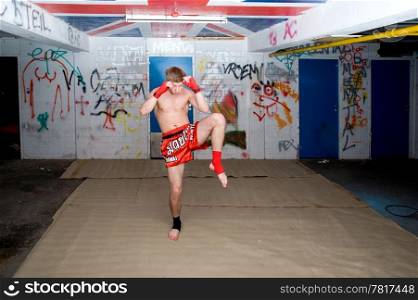 A Muay Thai figher warming up in a sburban basement