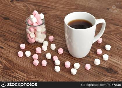 A mug and a jar filled with small marshmallows