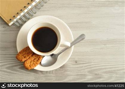 A mug of coffee, biscuits and a notebook