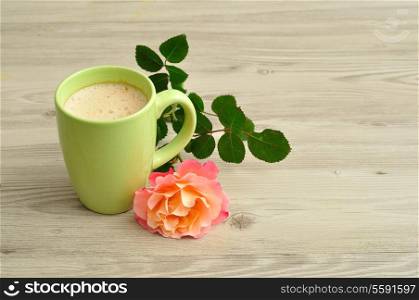 A mug of coffee with an orange rose