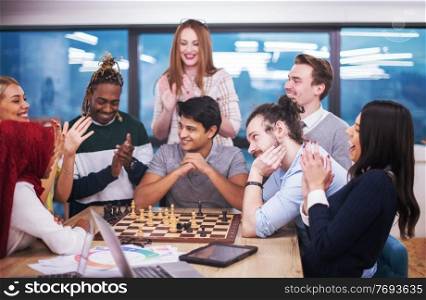 a multiethnic group of business people playing chess while having a break in modern startup office
