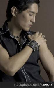 A muscular asian male model in leather and studs
