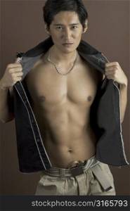 A muscular asian male model shows off his torso