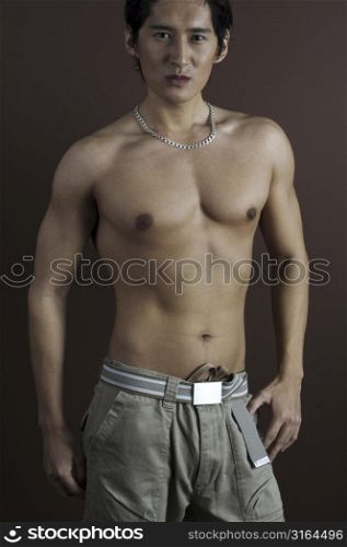A muscular asian model displays an impressive torso