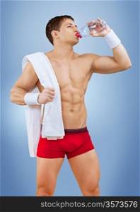 a muscular male drinking water from bottle