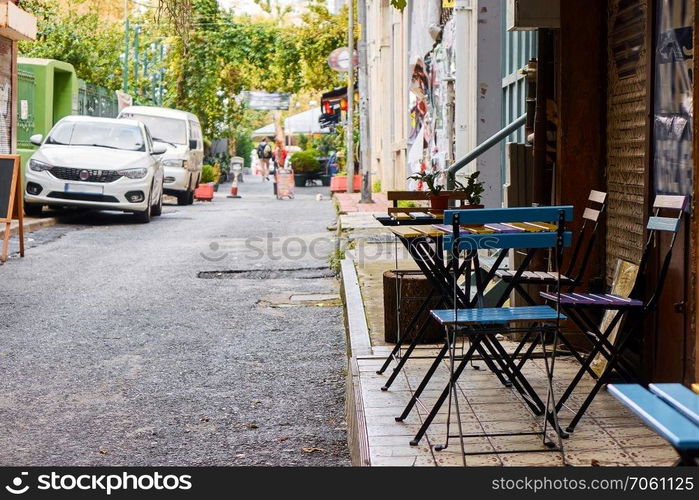 a narrow street in the city of Istanbul with a street cafe and parked cars. cafe in the narrow streets of Istanbul