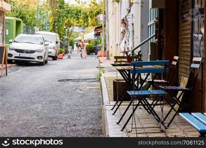 a narrow street in the city of Istanbul with a street cafe and parked cars. cafe in the narrow streets of Istanbul