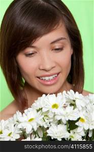 A naturally beautiful oriental woman make up free and holding a bunch of white flowers