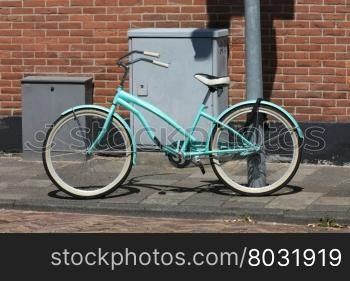 A new light blue bikes parked on a street