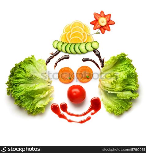 A nice and funny edible clown, made of strawberries, lemons, salad and so on.