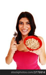 A nice brunette young woman in a red t-shirt holding a bowl of cerealin her hand for breakfast, isolated on white background.