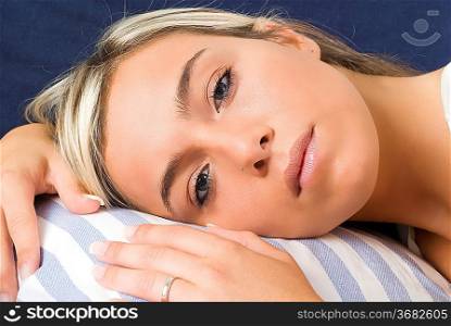 a nice close up of a young blond woman with the head on pillow and starting to sleep