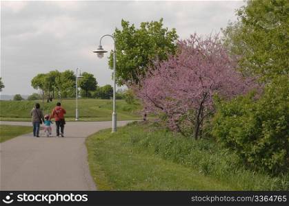 A nice park in Hamilton Ontario in the spring and a family is walkingalong the path.