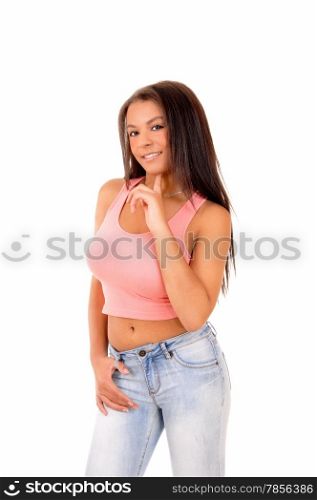 A nice picture of a young pretty teen girl standing in jeans and a pinktop, with her finger at her chin, isolated on white background.