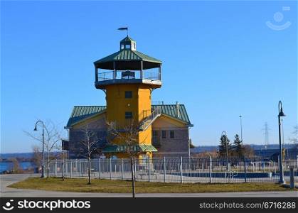 A nice restaurant in early spring on the lake Ontario in Hamilton, Canadawith a yellow tower and a swimming pool in front of.