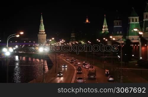A night view of the Moscow city Kremlin with an illuminated river and a bridge. Focus pulling - bokeh lights.
