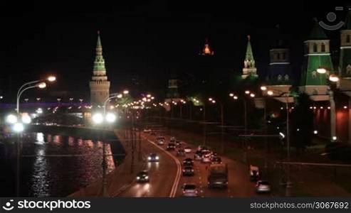 A night view of the Moscow city Kremlin with an illuminated river and a bridge. Focus pulling - bokeh lights.