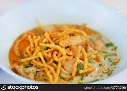 A noodle dish in a yellow curry with chicken. Khao soy a famous northern Thai food.