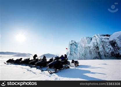 A number of snowmobiles near a glacier in Svalbard, Norway