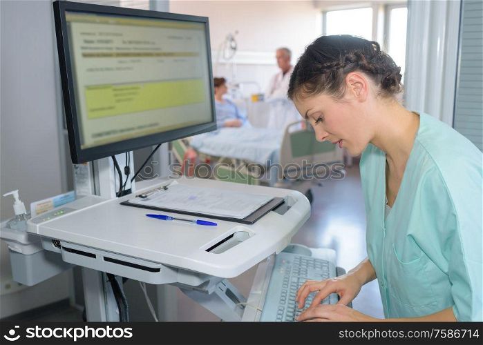 a nurse checking hospital screen