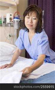 A Nurse Making A Bed In A Hospital Ward