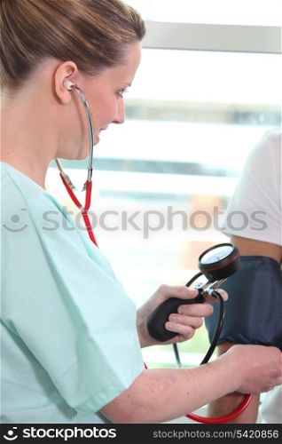 a nurse taking blood pressure of a patient