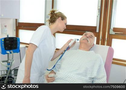 a nurse taking patients temperature