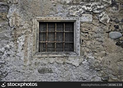 A old barred window in a stone wall