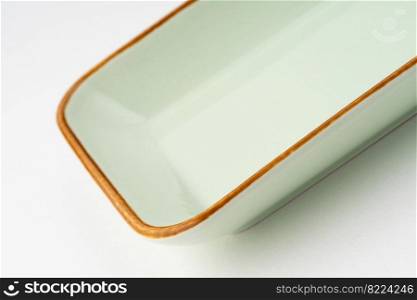 A one ceramic green rectangular plate isolated on white background. One ceramic green rectangular plate isolated on white background