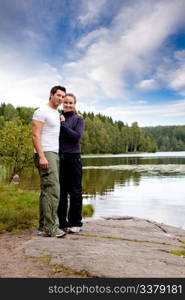 A outdoors couple portrait by a lake and forest